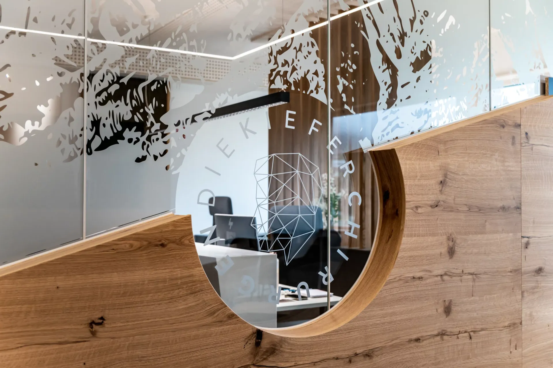 Praxiseingang des Dental Chalet von außen durch eine Glasscheibe mit Firmenname
