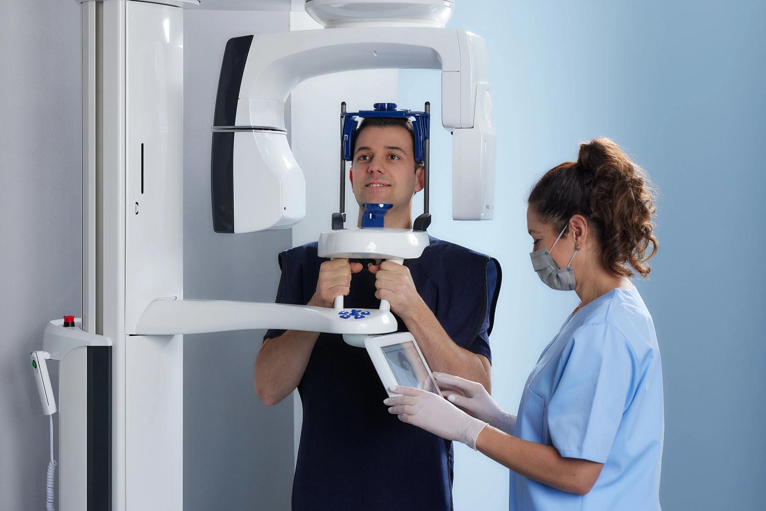 Patient wird geröngt und Assistentin stellt gerät ein