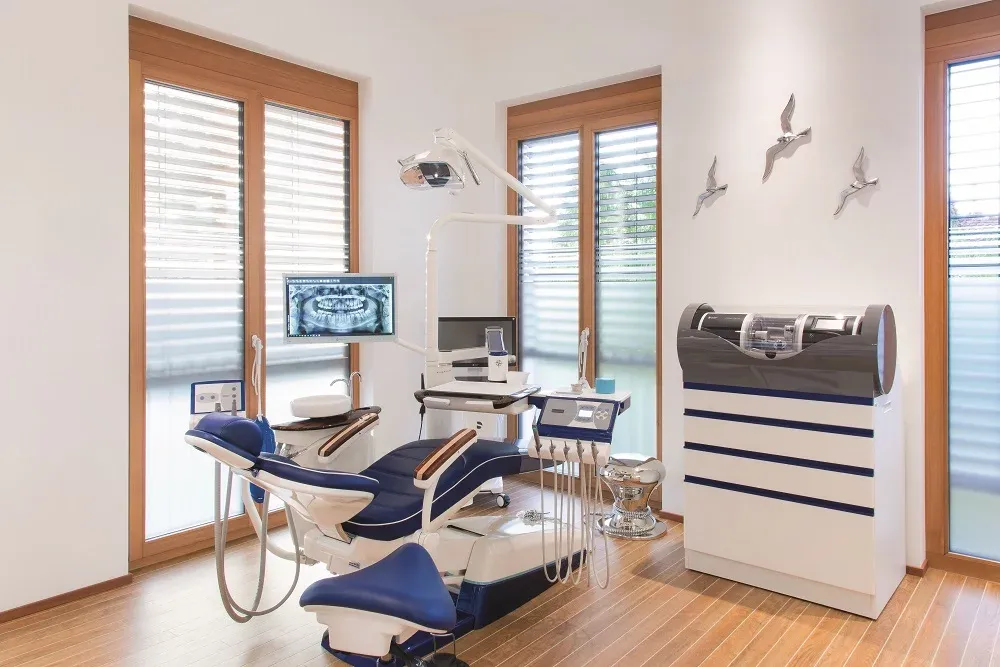 Behandlungszimmer in Segeloptik mit blauer Behandlungseinheit und Möwendekor aus Weitwinkelperspektive.