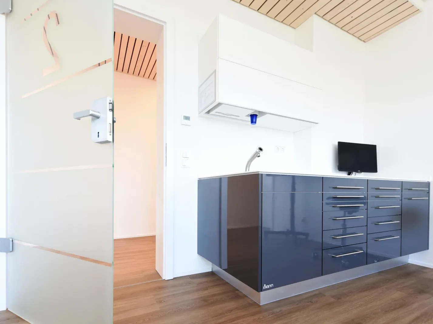 Eingang zum Behandlungsraum mit Holz-Designelementen und moderner Innenarchitektur.