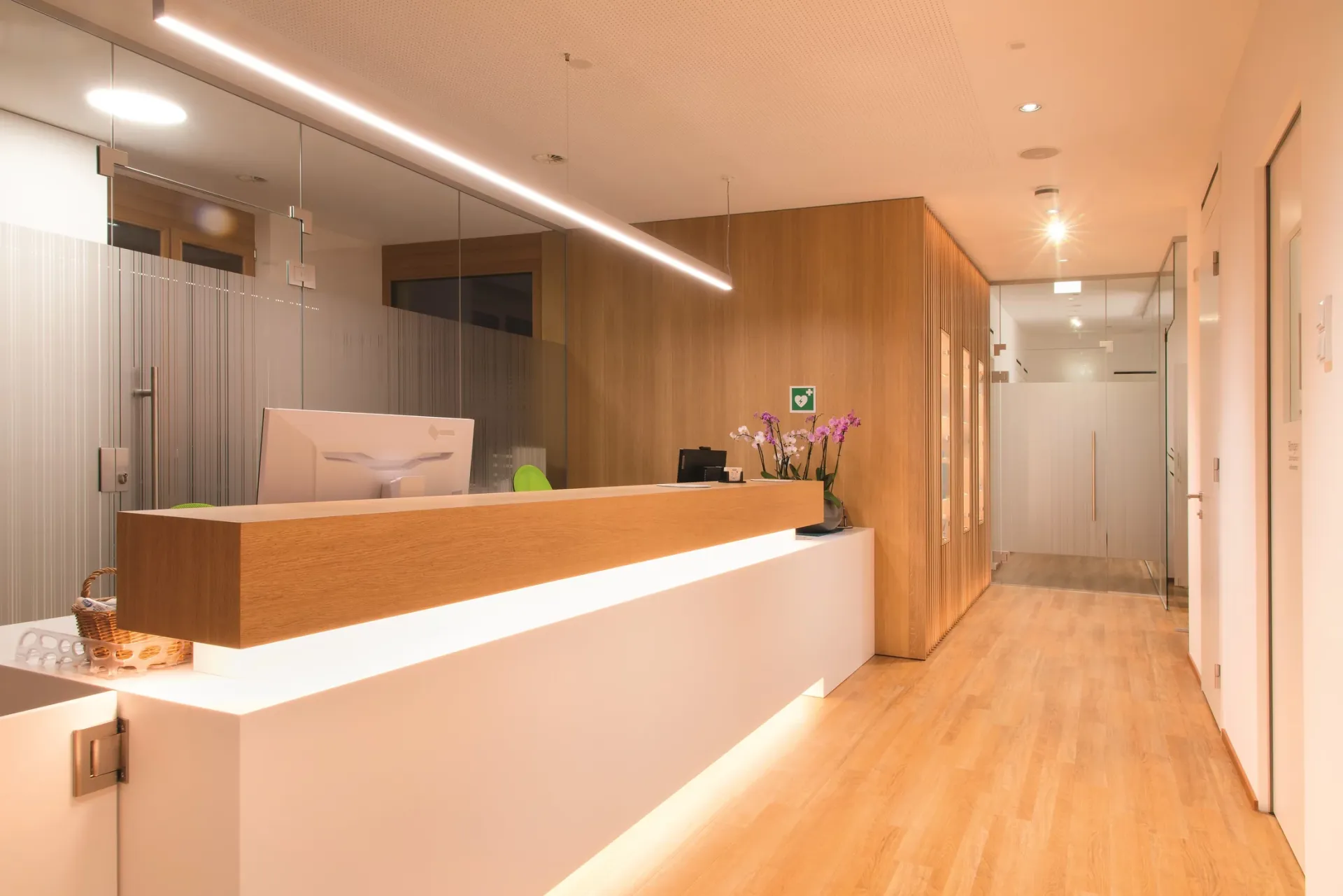 Empfangsbereich mit moderner Holztheke und Beleuchtung.