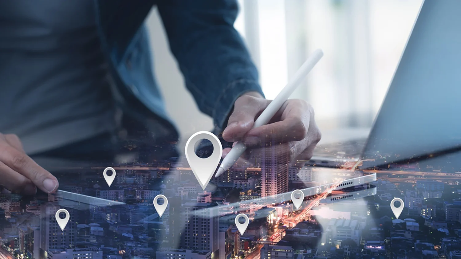 Eine Person benutzt einen Stift auf einem Tablet mit einer digitalen Stadtkarte und eingeblendeten Kartensymbolen.