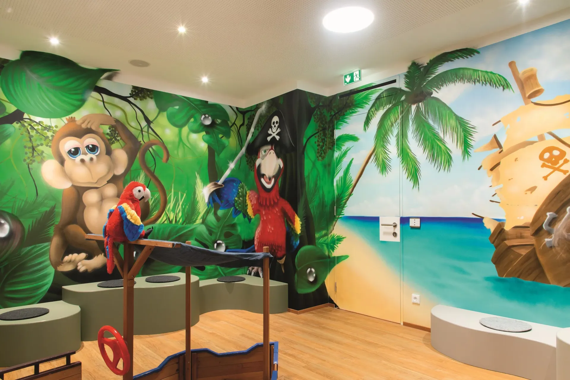 Behandlungszimmer in Piratenoptik mit Wandbildern eines Piratenschiffs und verspielten Motiven.
