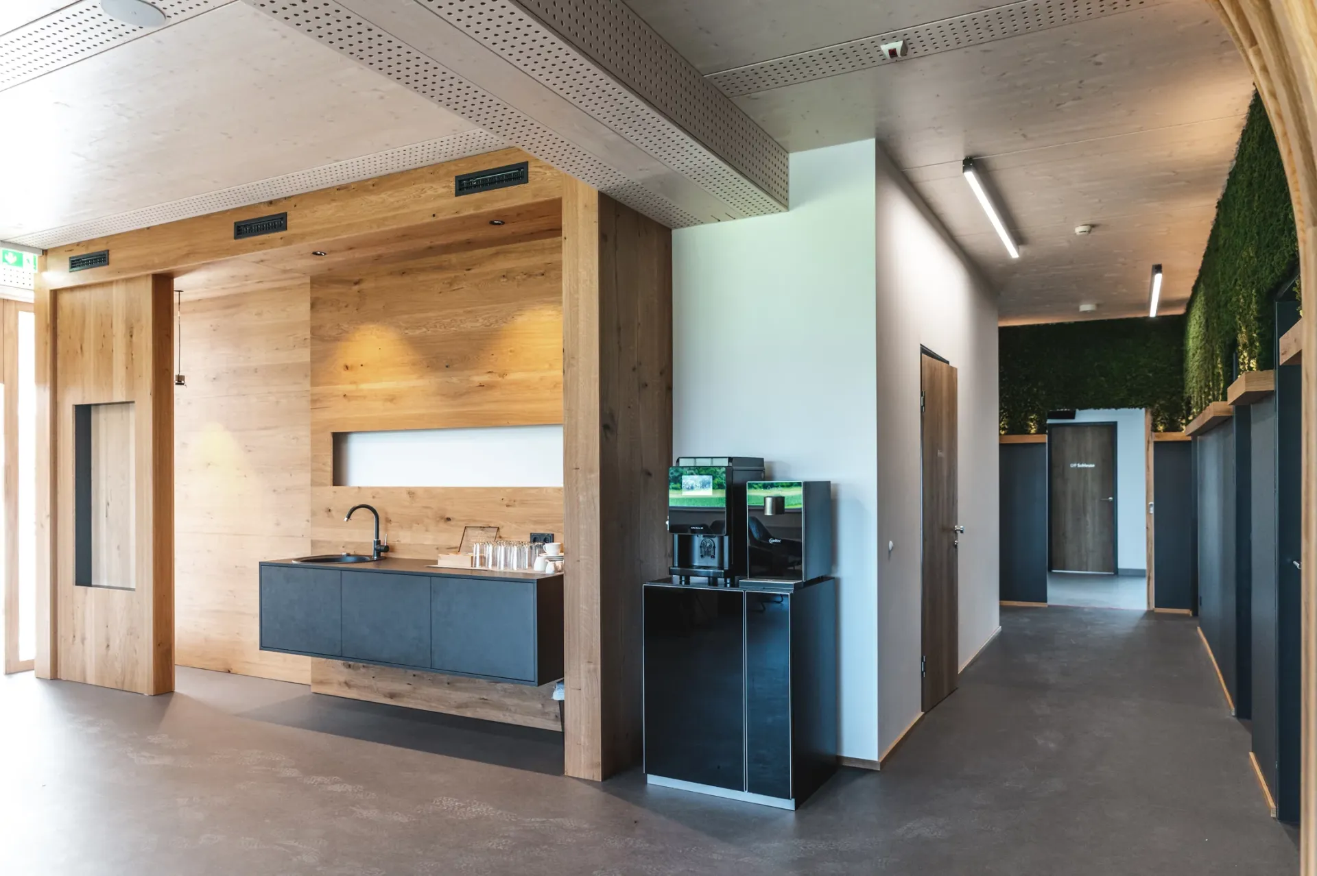 Empfangsbereich mit Kaffeeautomat und Waschbecken.