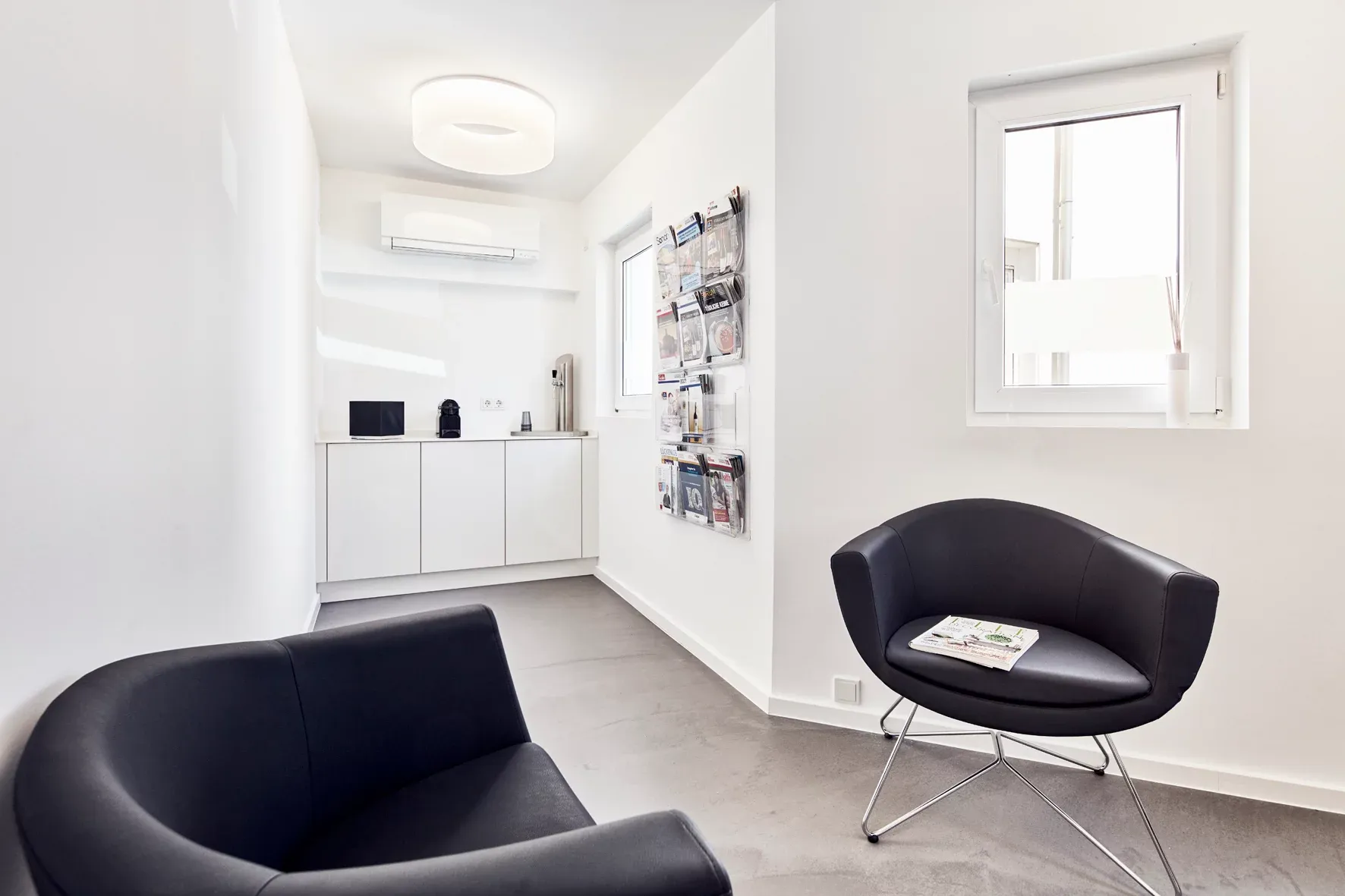 Wartezimmer mit Blick auf Wasserspender und Kaffeeautomat.