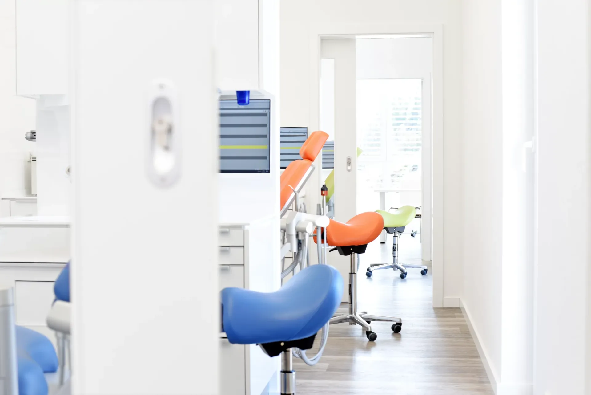 Sitzbereich mit mehreren Stühlen in Blau, Orange und Grün.