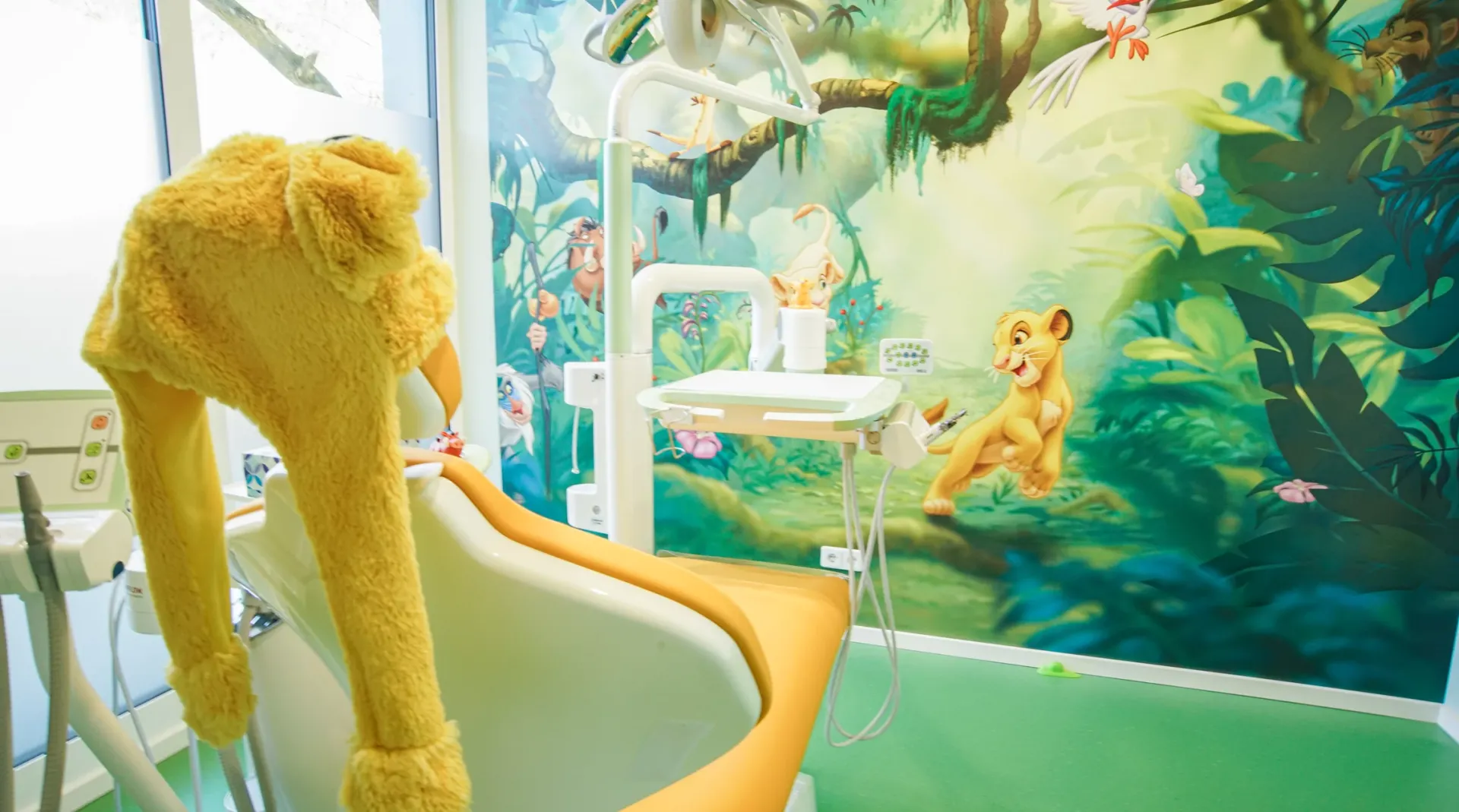 Behandlungsraum mit Löwen-Thema und Behandlungseinheit.