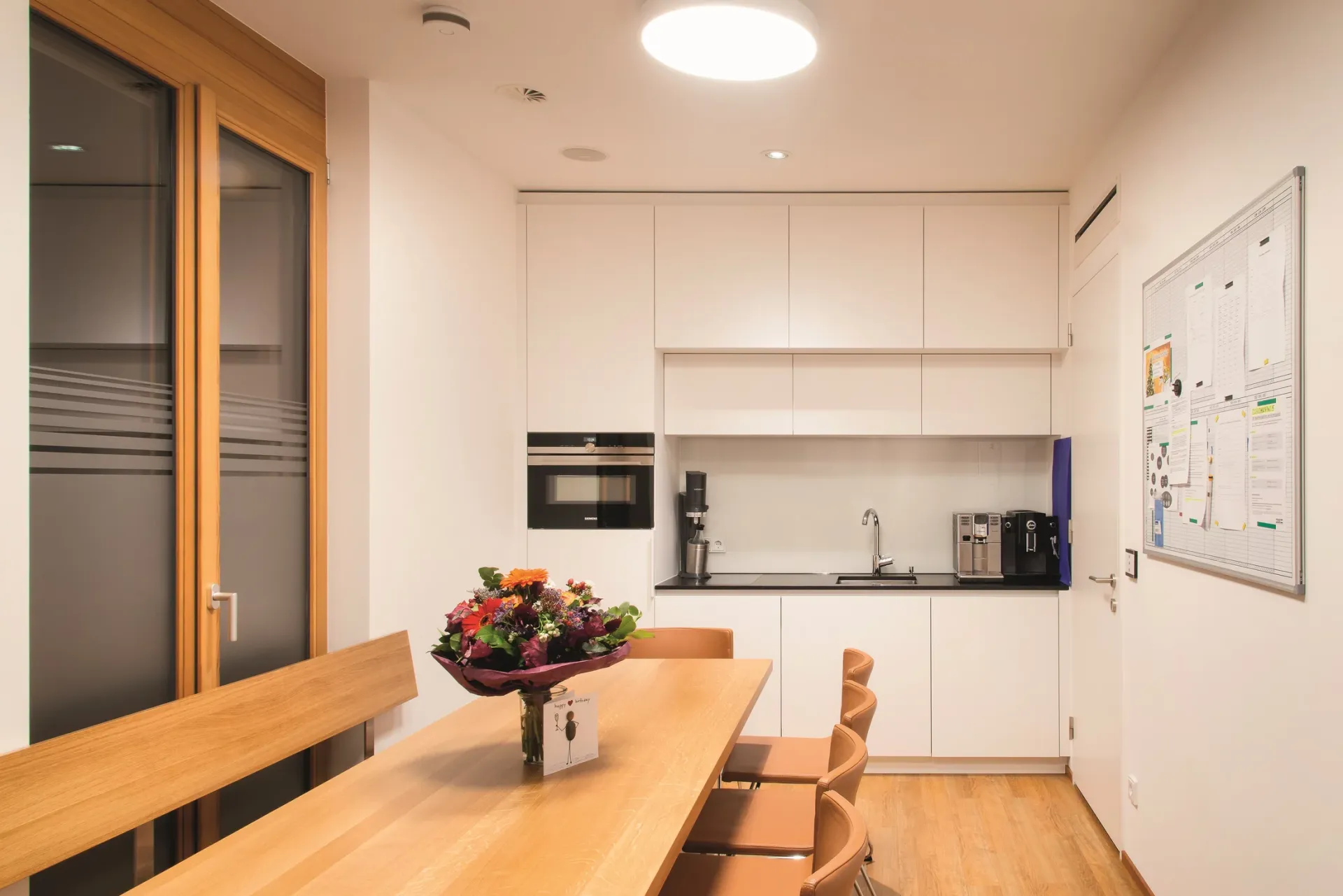 Pausenraum für Mitarbeitende mit Küchenzeile und Tisch.