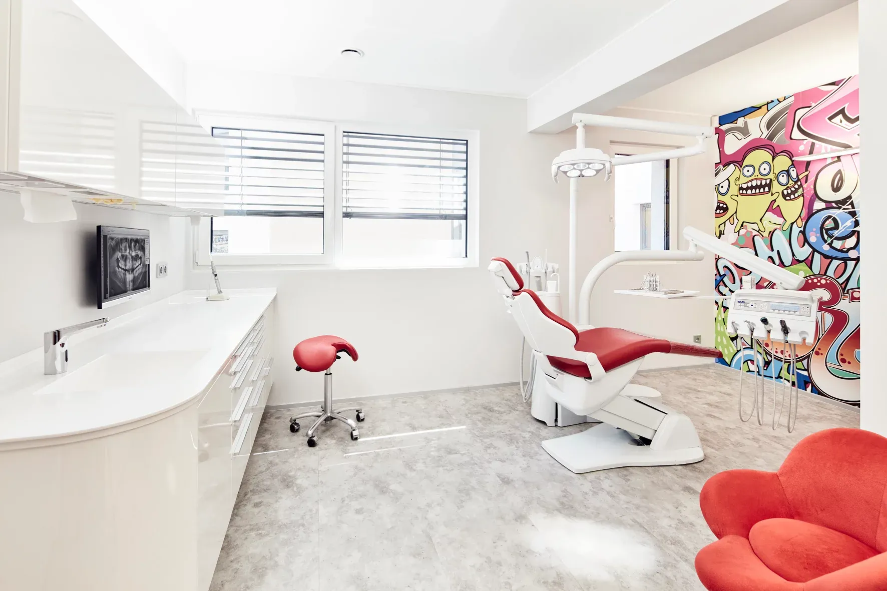 Behandlungszimmer mit moderner Ausstattung und farbenfrohem Graffiti an den Wänden.