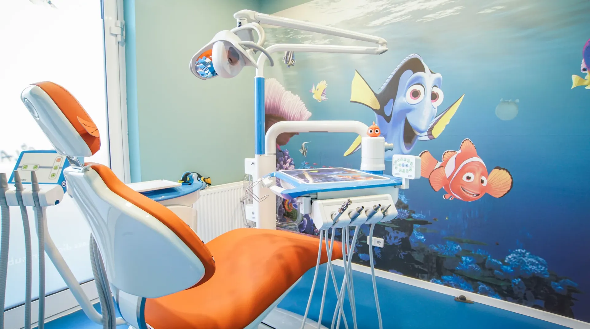 Behandlungsraum mit Unterwasser-Thema und thematisch gestalteten Wänden.