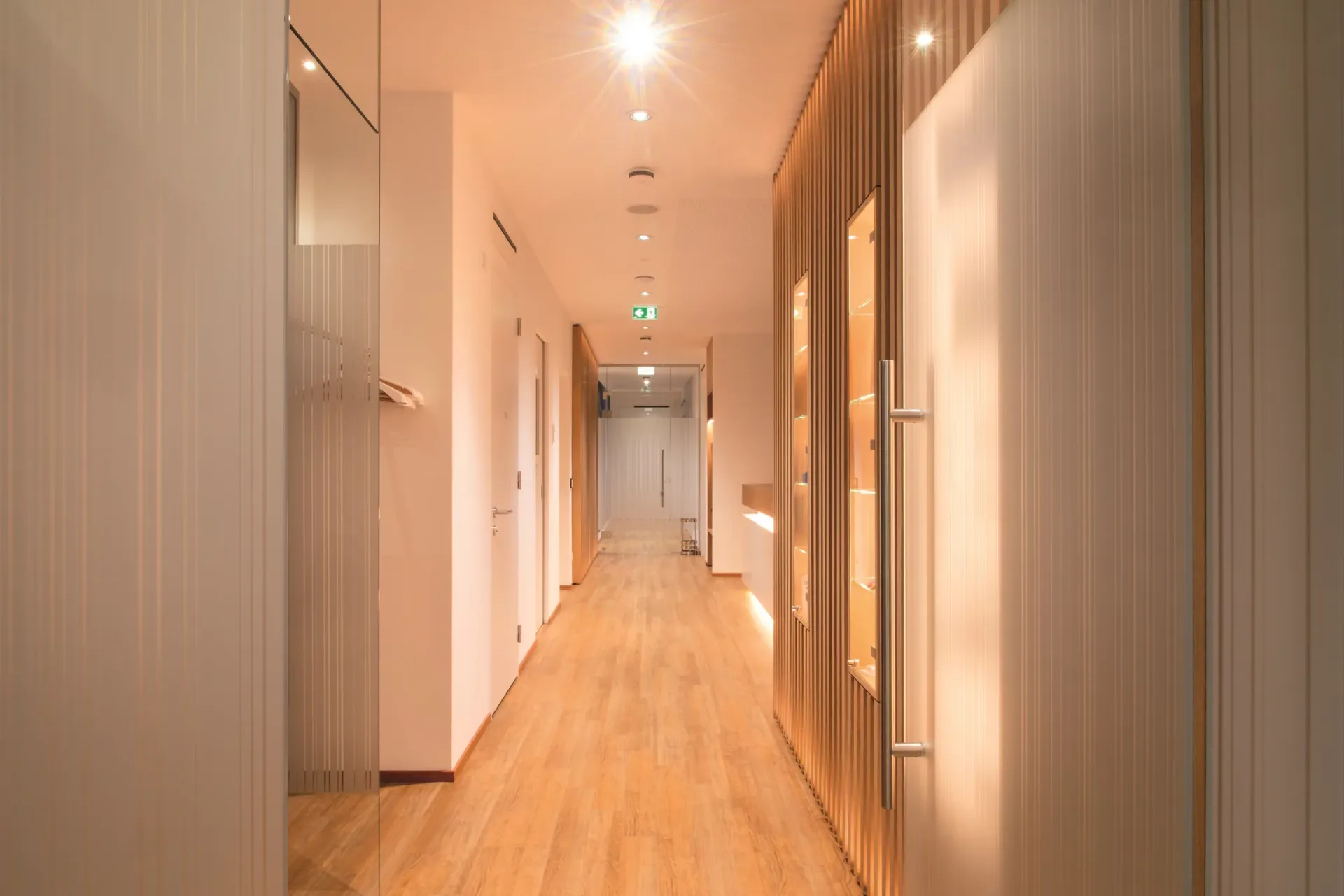 Flur der Praxis mit hellem Holzboden und Holzverkleidung an den Wänden.