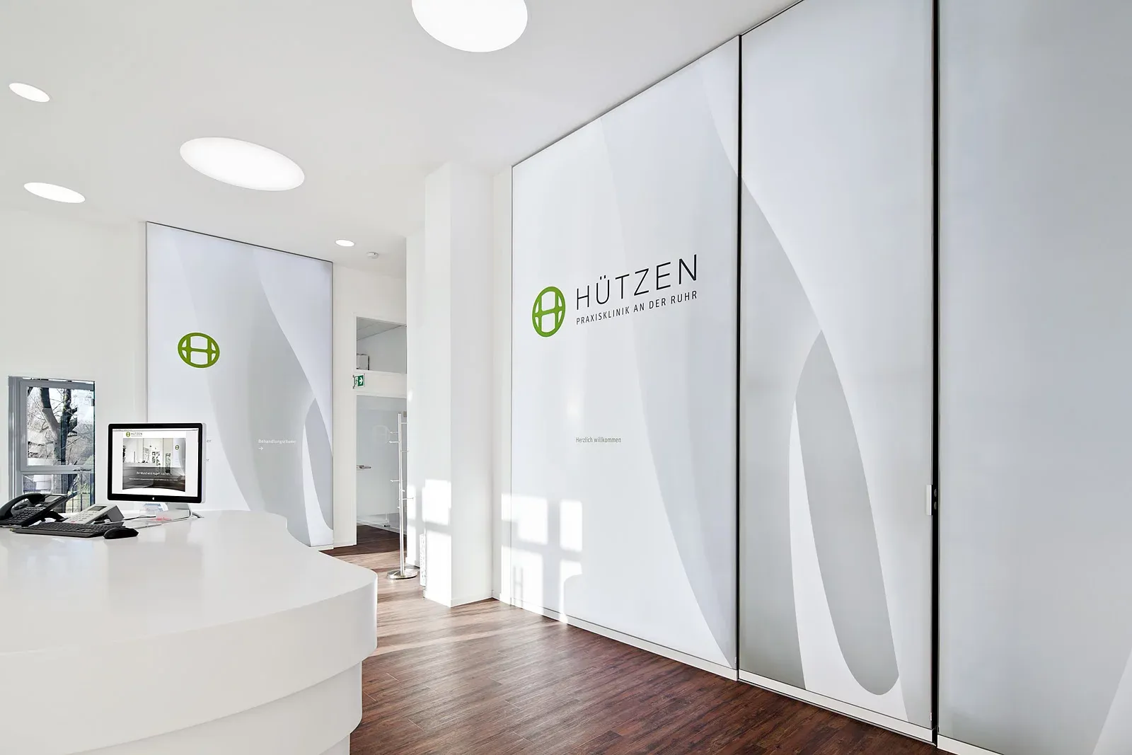 Empfangsbereich der Praxis mit dem Schriftzug „Hützen“.