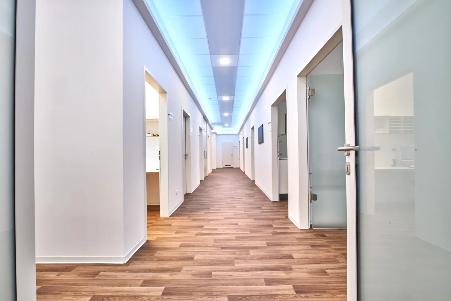 Flur mit Behandlungsräumen auf der linken und rechten Seite.