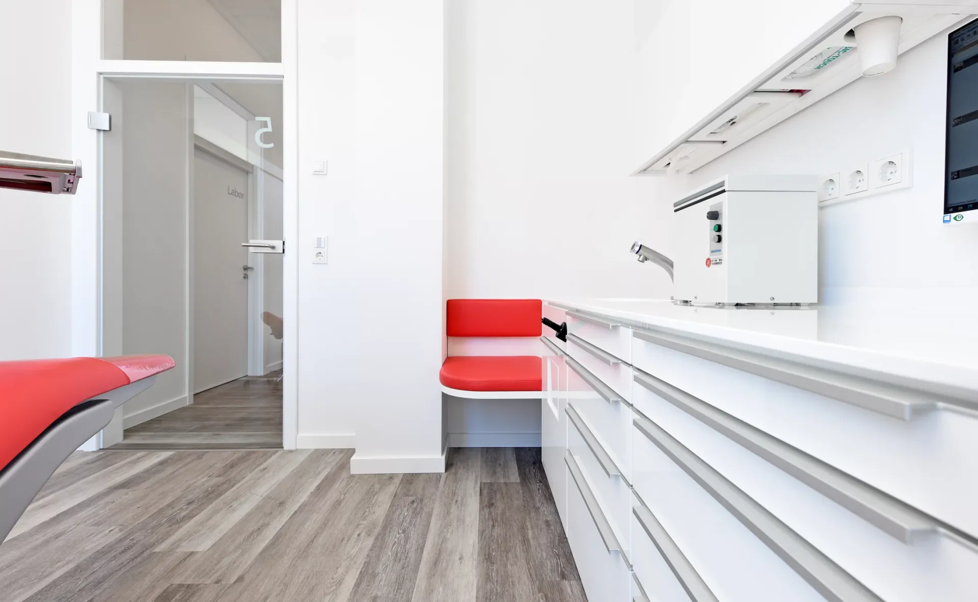 Behandlungszimmer mit Regalen zur Aufbewahrung von Materialien.