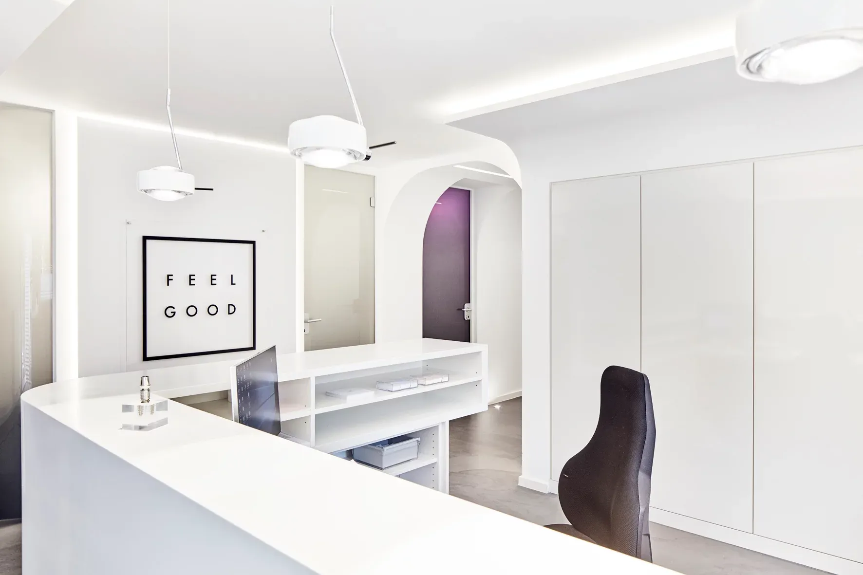 Empfangsbereich der Praxis in schlichter, weißer Gestaltung.