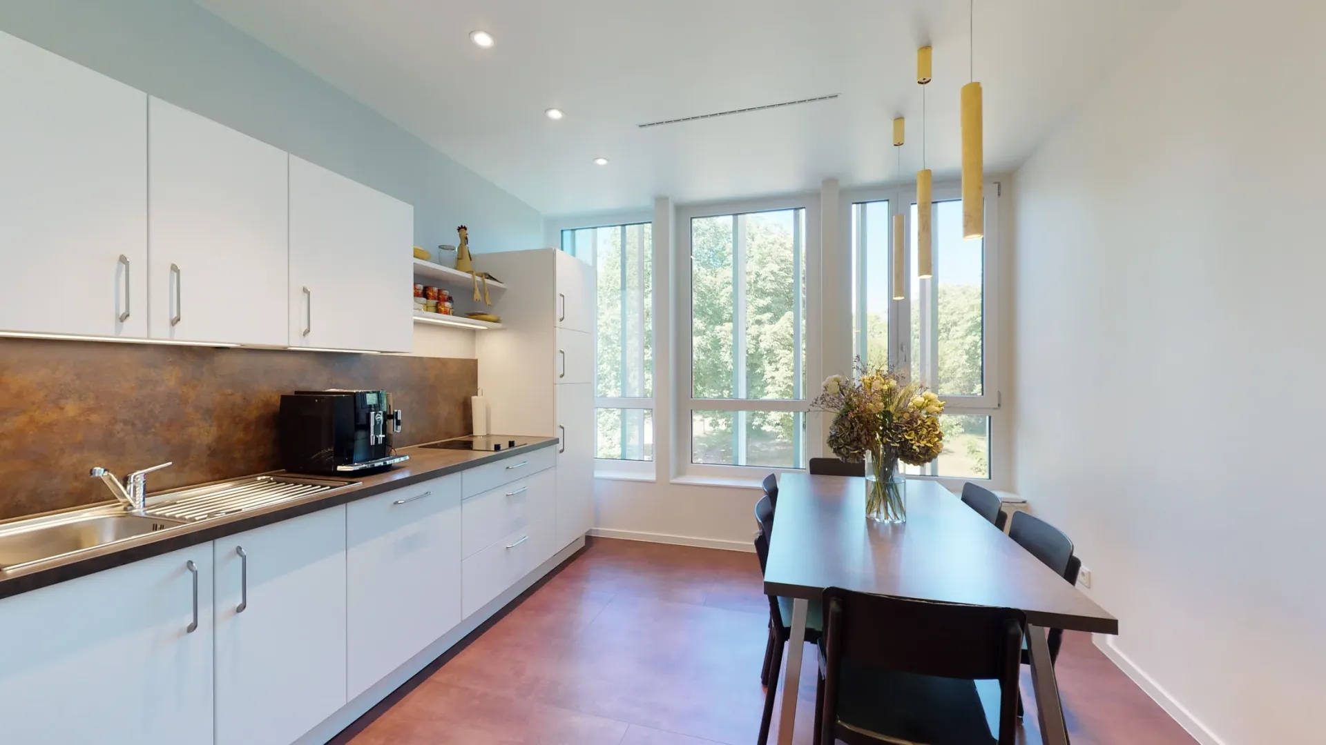 Pausenraum mit Küchenzeile und Tisch.