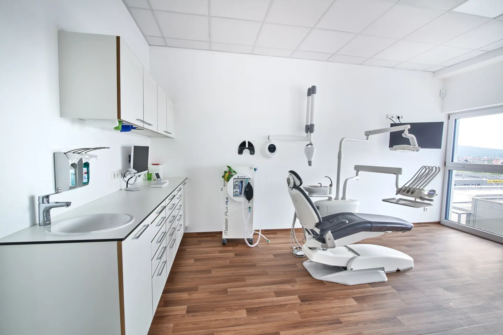 Behandlungszimmer mit Schränken und Behandlungseinheit.