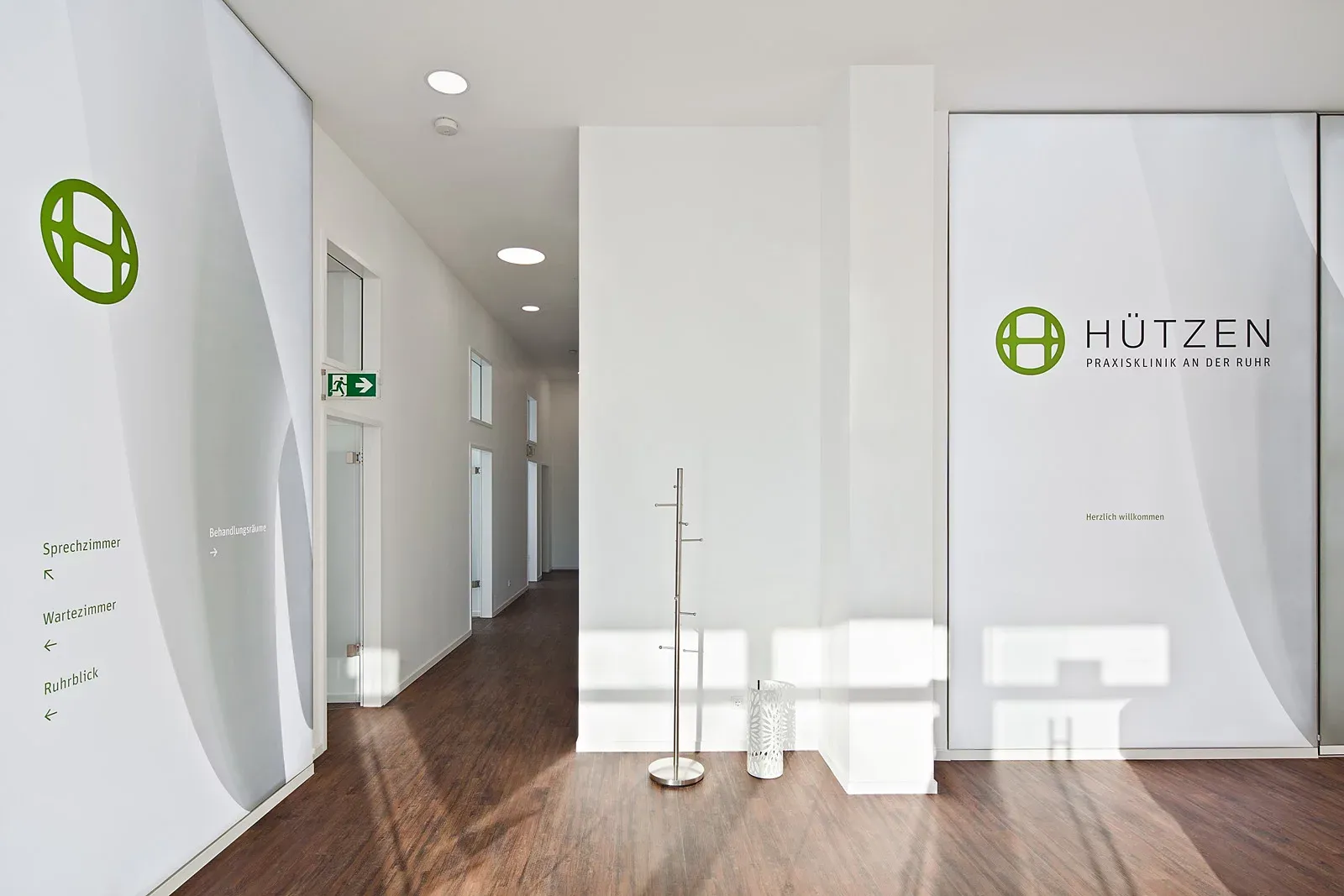 Flur der Praxis mit braunem Holzboden.