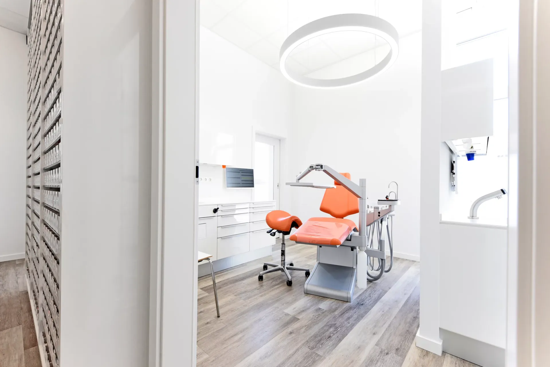 Behandlungszimmer mit oranger Behandlungseinheit.
