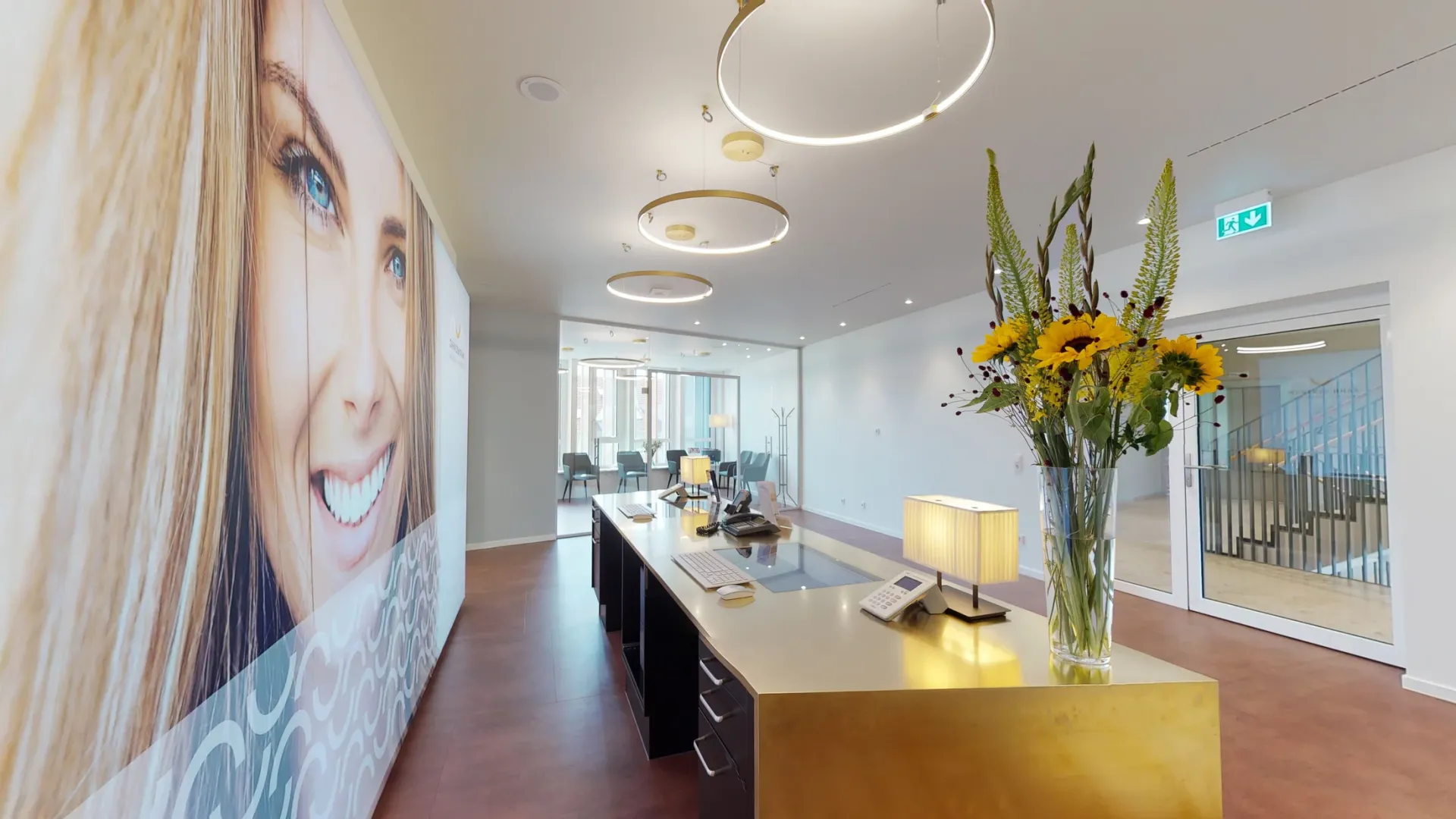 Empfangstheke der Praxis aus der Seitenansicht mit Blick auf Wartezimmer und Eingangstür.