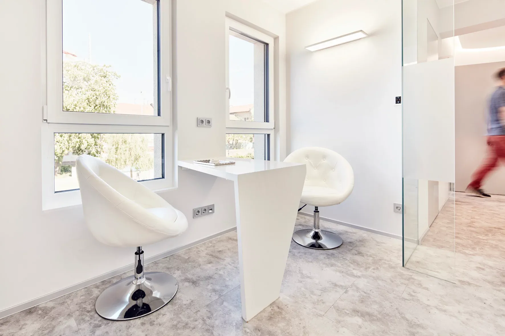 Behandlungszimmer mit modernen Drehstühlen und medizinischer Ausstattung.